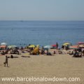 People enjoying the sunshine on Barcelona's beach, playing beach tenis, swimming or shading under parasols