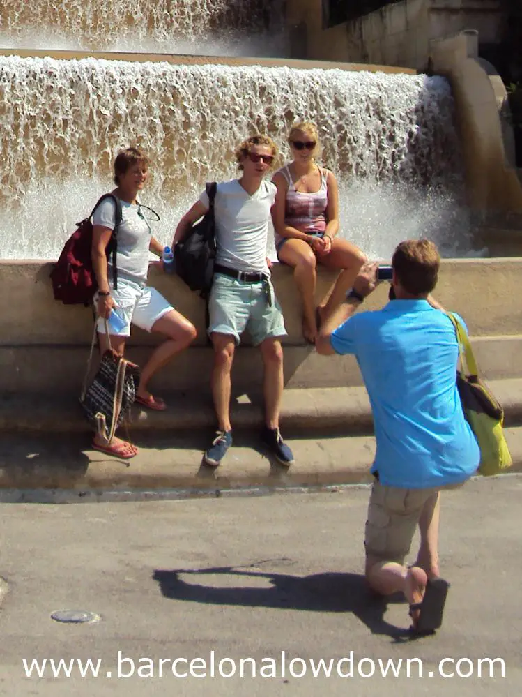Tourists taking photos in front of a fountain near the MNAC Barcelona