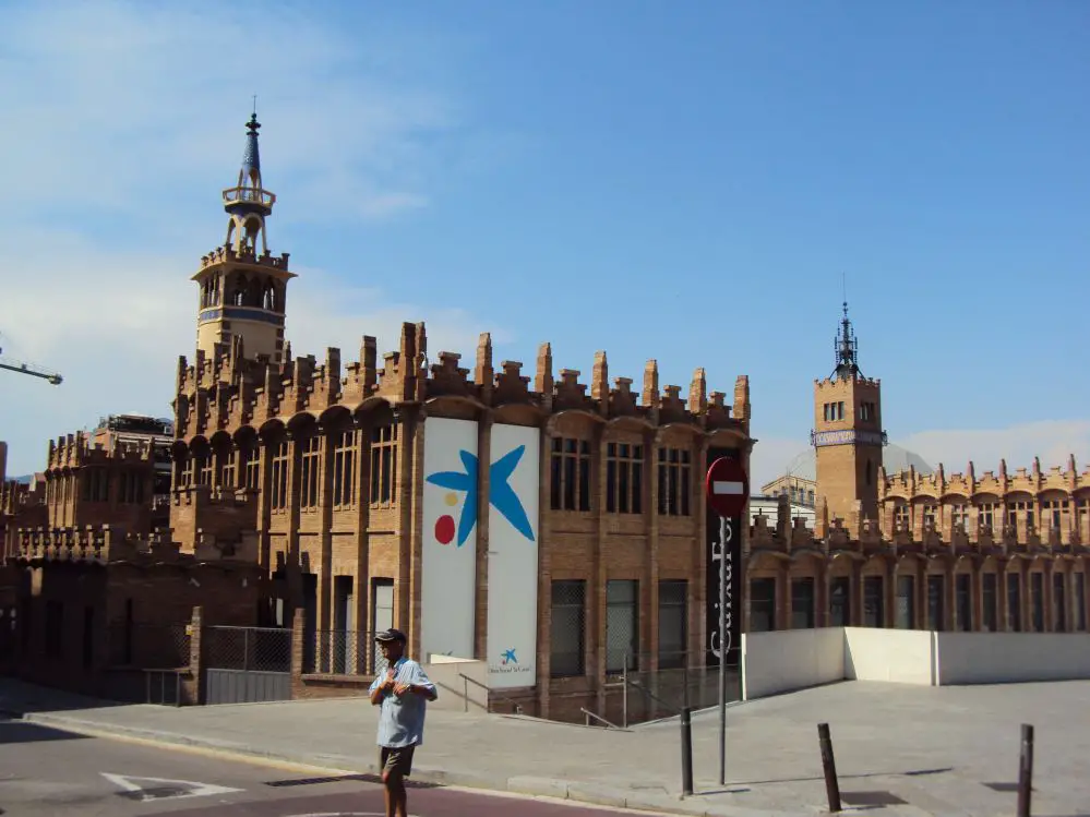 A man crosses the street in front of the Caixa Forum Barcelona