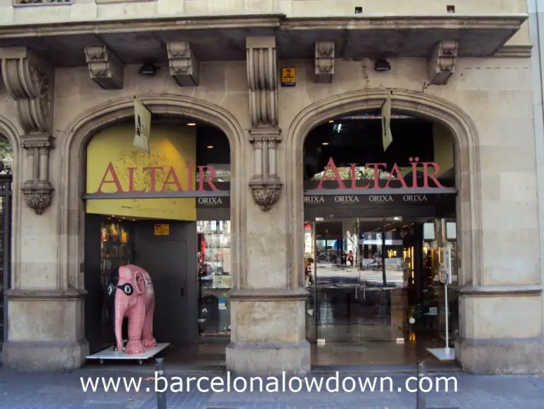 Photo of the Altaïr travellers bookshop barcelona on Gran Via with a masked pink elephant in the foreground
