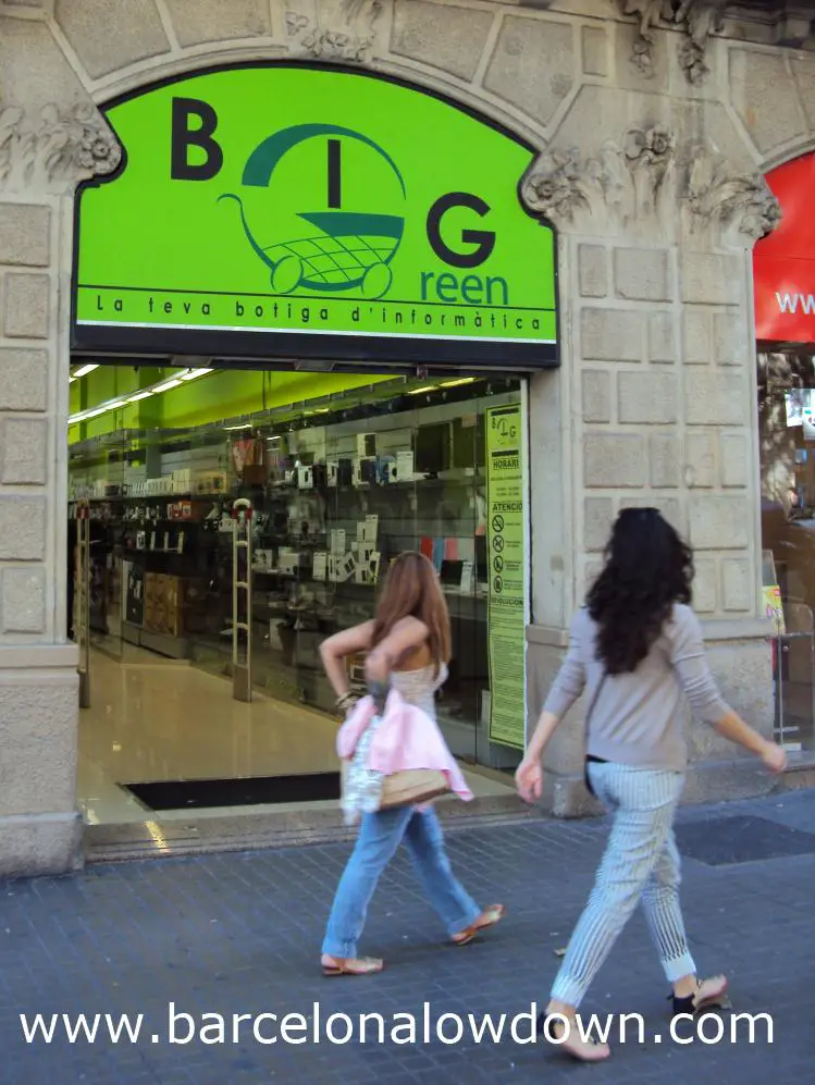 2 girls walking past a computer store in Barcelona