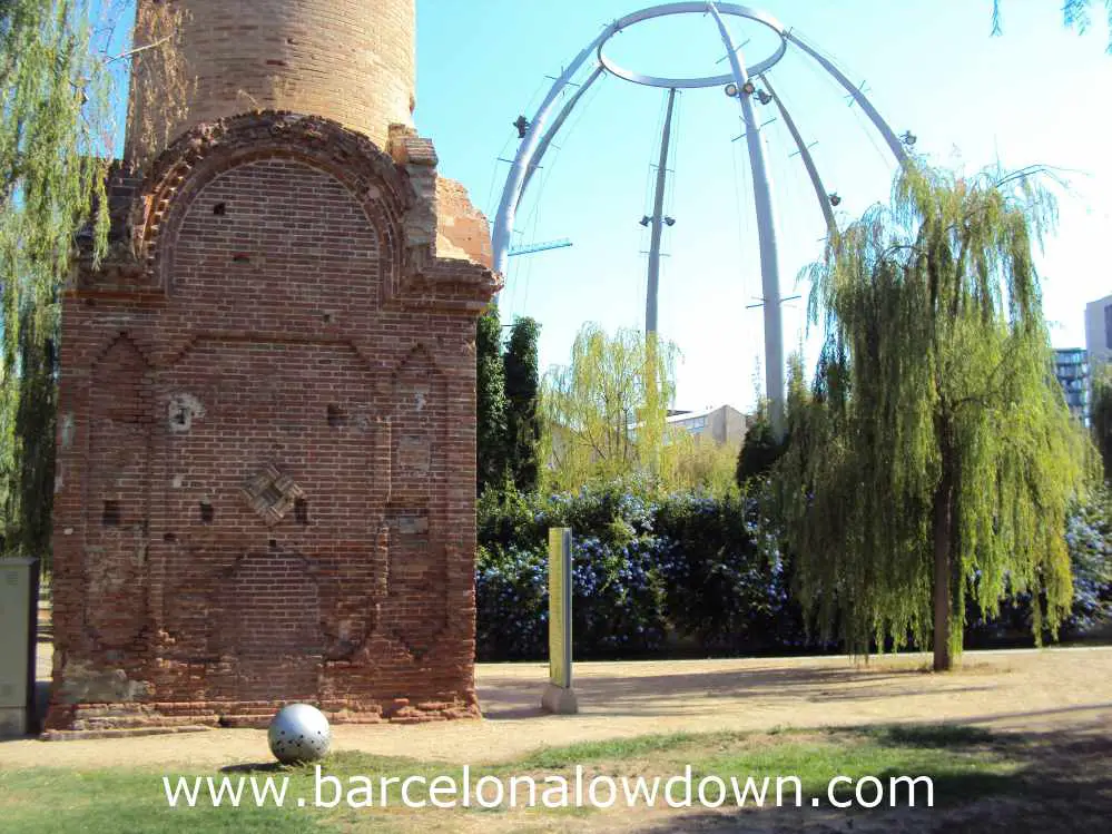 Old brick chimney in front of a steel dome in Poblenou's Central Park, Barcelona