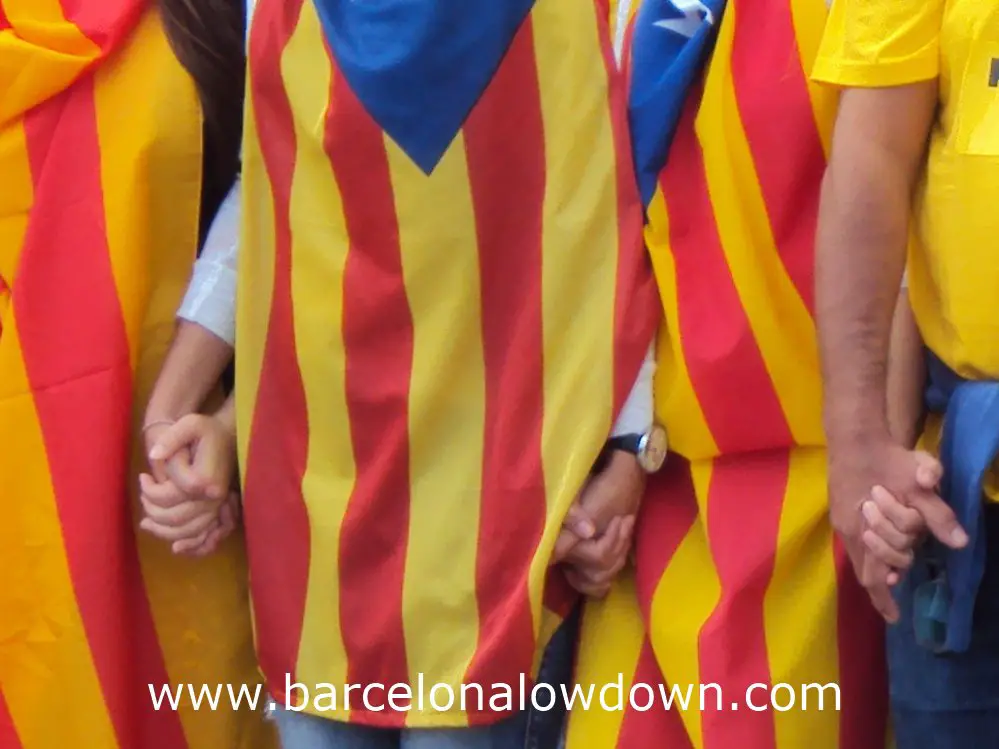 Catalans dressed in Catalan independence flags holding hand as part of the 400km long "Catalan Way" in Barcelona