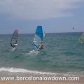 3 windsurfers and a kiesurfer sailing at Badalona beach near Barcelona