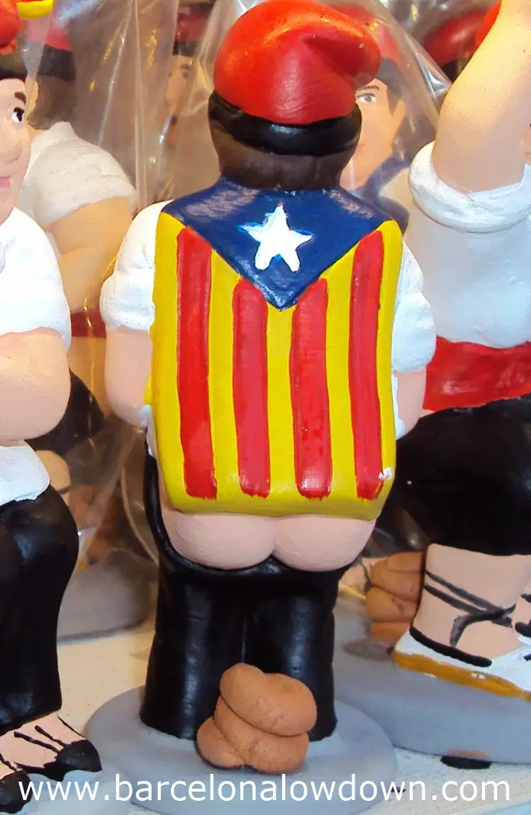 Caganer figurine draped with a Catalan nationalist flag or estelada