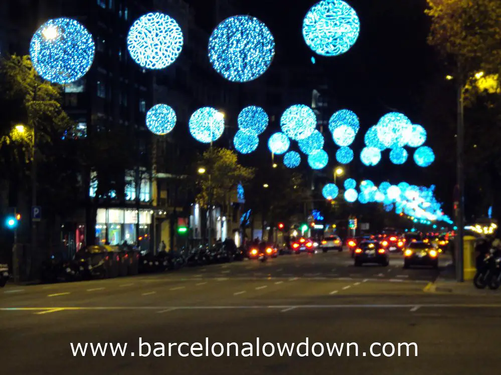 Christmas lights hanging above cars and taxis in central Barcelona