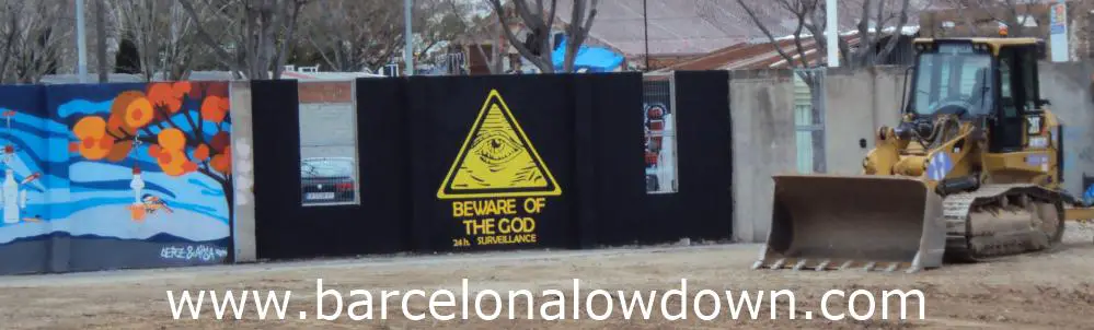 Photo of a bulldozer in front of walls covered in graffiti.