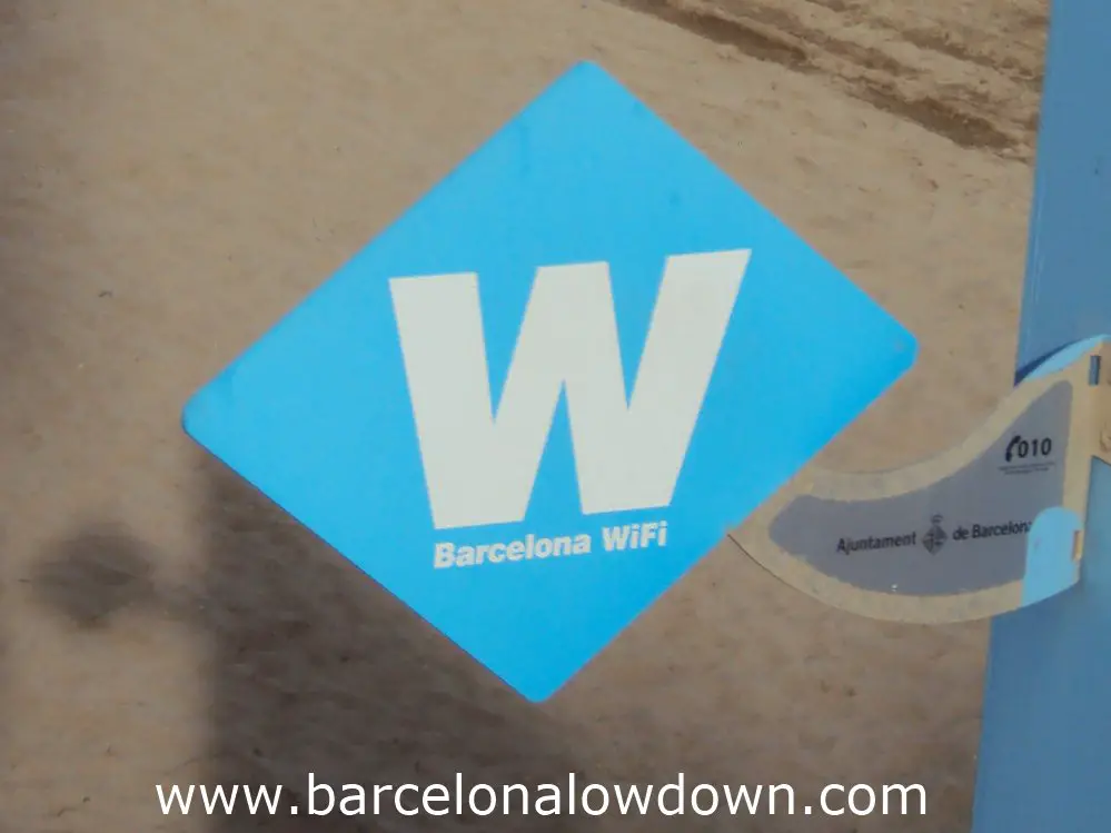 Blue W sign indicating a free Barcelona WIFI hotspot on the Barceloneta beach.