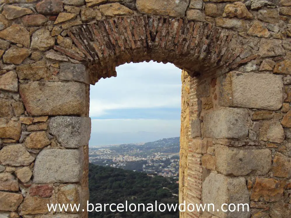 View of Barcelona through a medieval stone arch