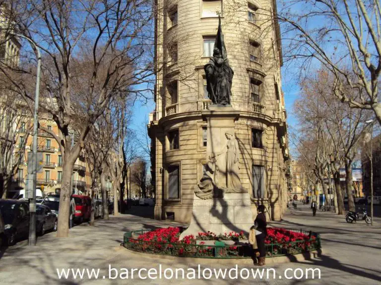 Statue of Rafael Casanova in the Eixample district of Barceona, The statue is surrounded by trees and elegant old buildings.