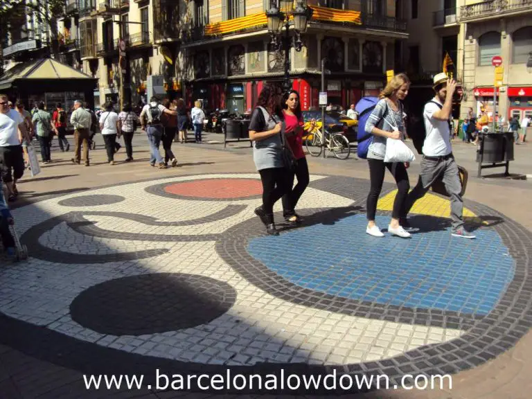 Tourists walking over Miro's famous mosaic on the Ramblas pedestrianised avenue in central Barcelona