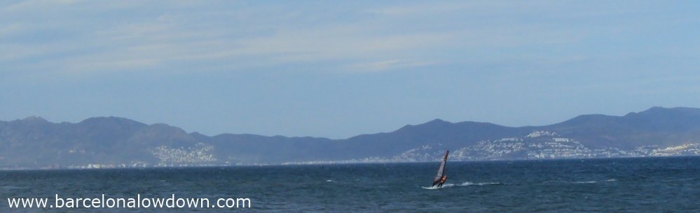 A windsurfer sailing in the Bay of Roses on the Spanish Costa Brava