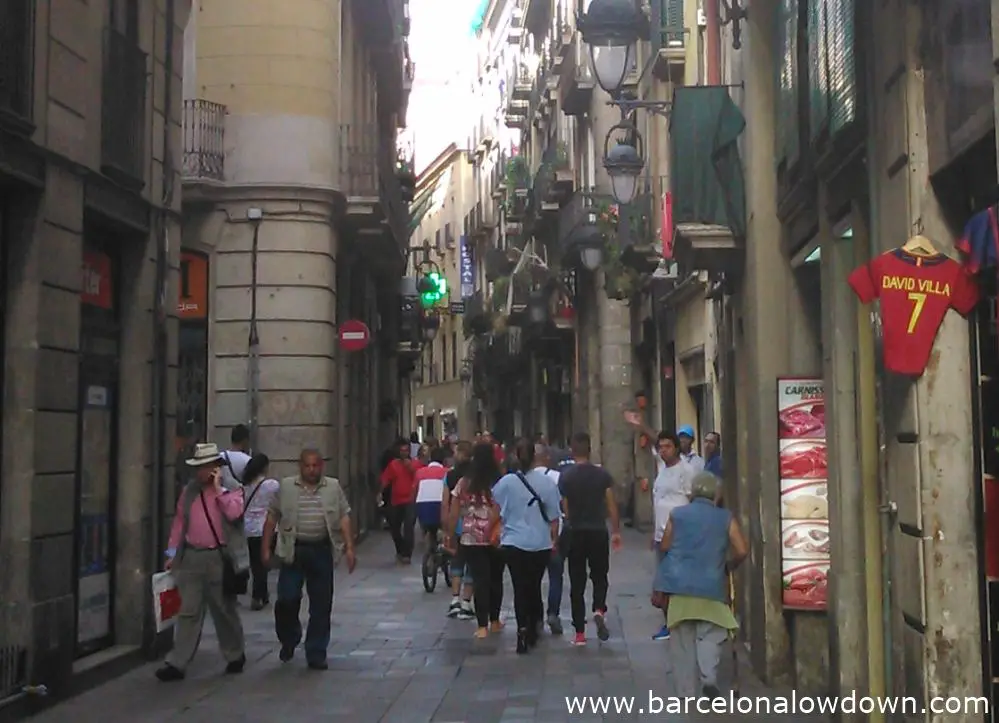 A typical narrow crowded street in Barcelonas colourful Raval neighbout¡rhood.