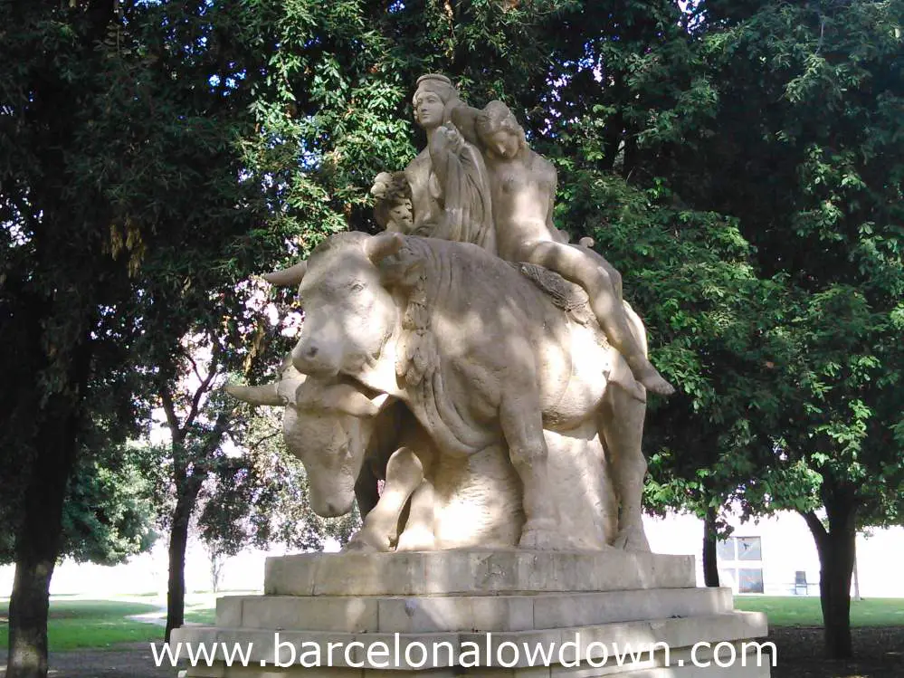 Stone statue of two girls riding atop a bull in Barcelona