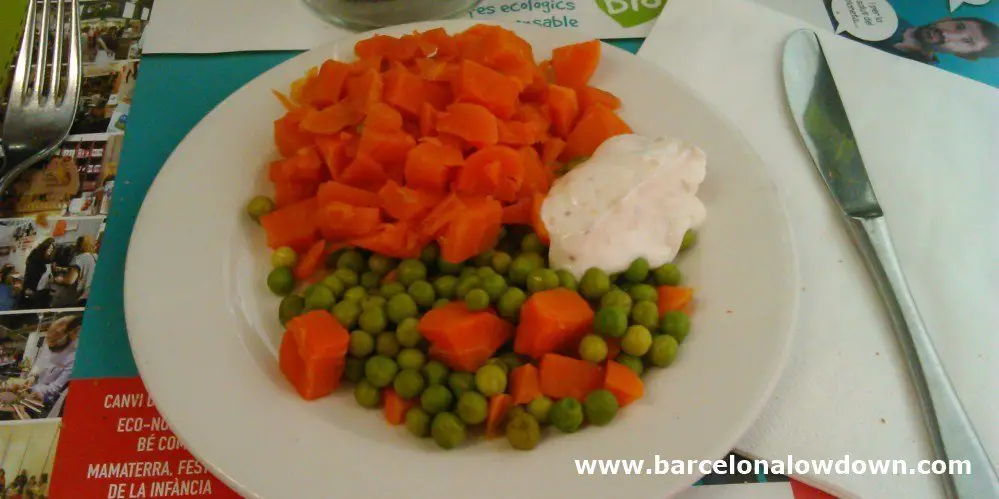 Simple dish of fresh carrots and pease served with delicious yougurt sauce at Arc Iris vegetarian restaurant Barcelona