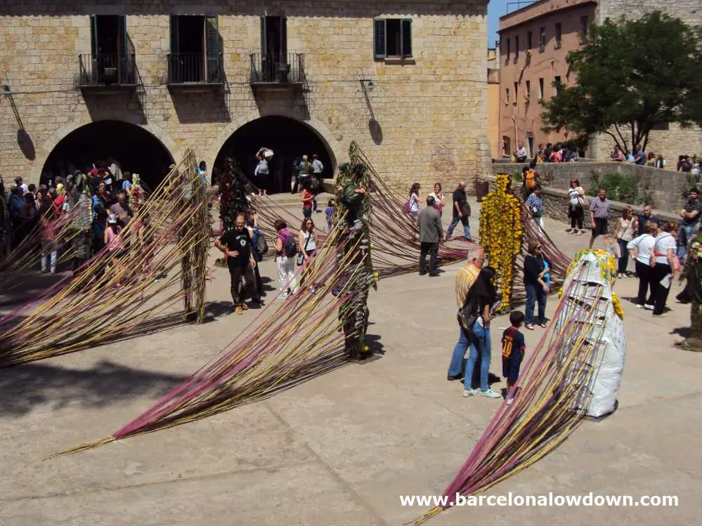 Giant humanoid flower arrangements in a Spanish town square