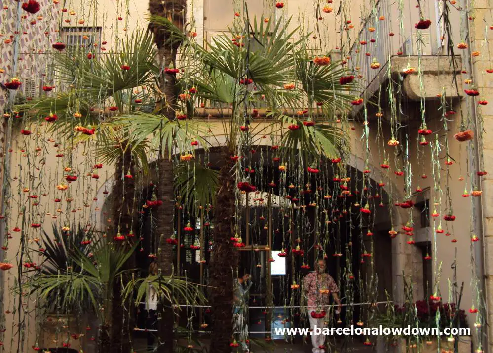 Hundreds of hanging flowers which decorate a patio inside an old building in the historic Jewish quarter of Girona, Catalonia