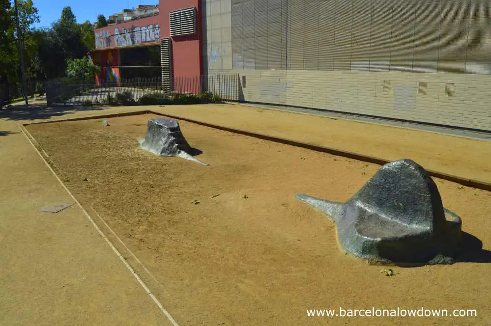 Statue of a submarine buried in sand in a park in Barcelona