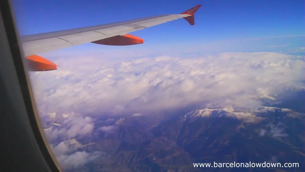 View of snow capped mountains out of the window of an easyjet flight between London Gatwick and Barcelona airport.