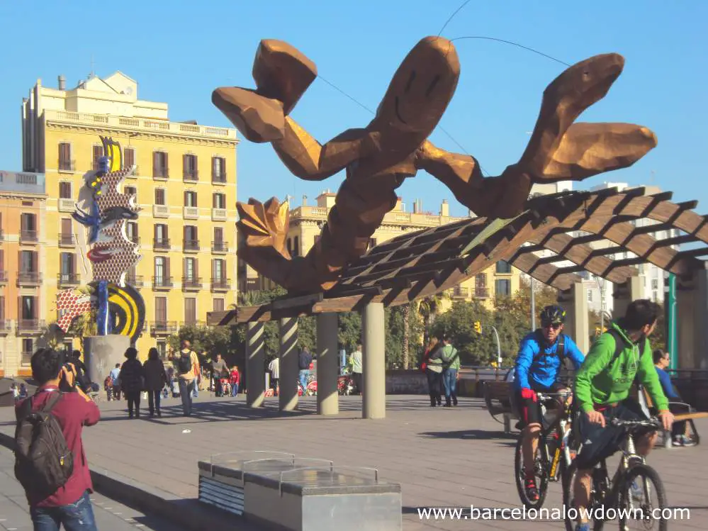 The Gambrinus giant smiling crayfish statue and the pop art style Barcelona's Head at Barcelona's Port Vell old harbour