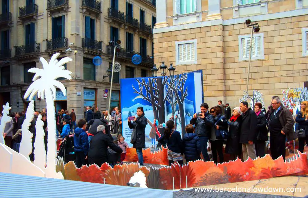Families queuing up to take photos with the nativity scene in front of Barcelona city hall