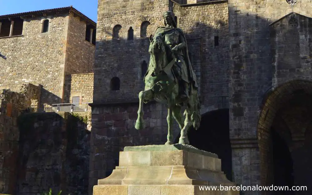 Equestrian statue of Ramon Berenguer III in front of a stretch of Barcelona's ancient Roman walls.