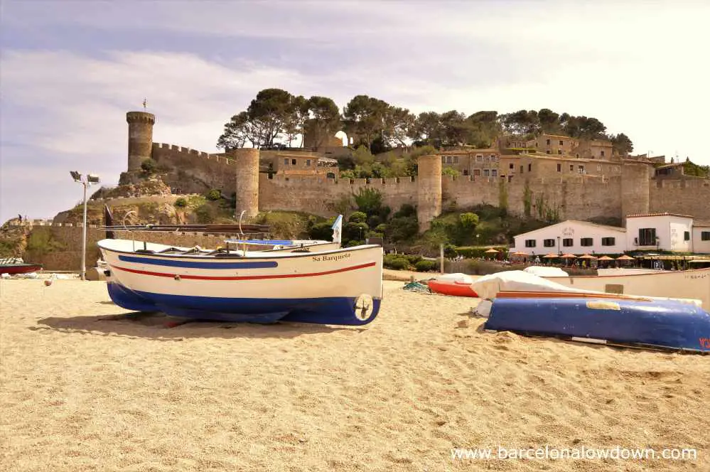 Traditional fishing boats on the beach in front of the medieval castle, Tossa de Mar