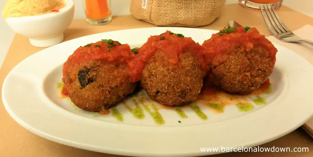 Starter of 3 arancini made with locally sourced rice and cheese served at the Aguaribay vegetarian restaurant in Barcelona
