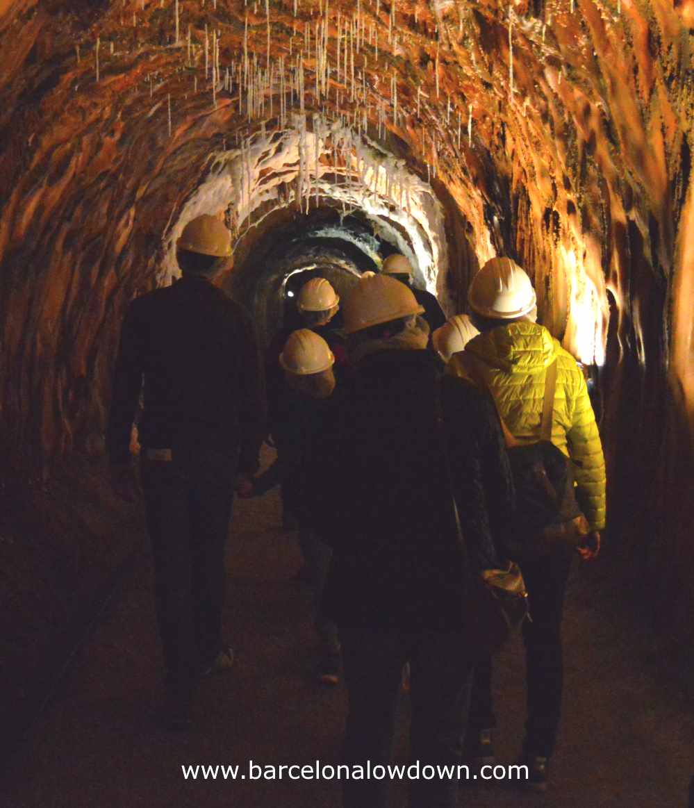 A group of helmeted tourists are led through the tunnels and chambers of the Cardona salt mine near Barcelona