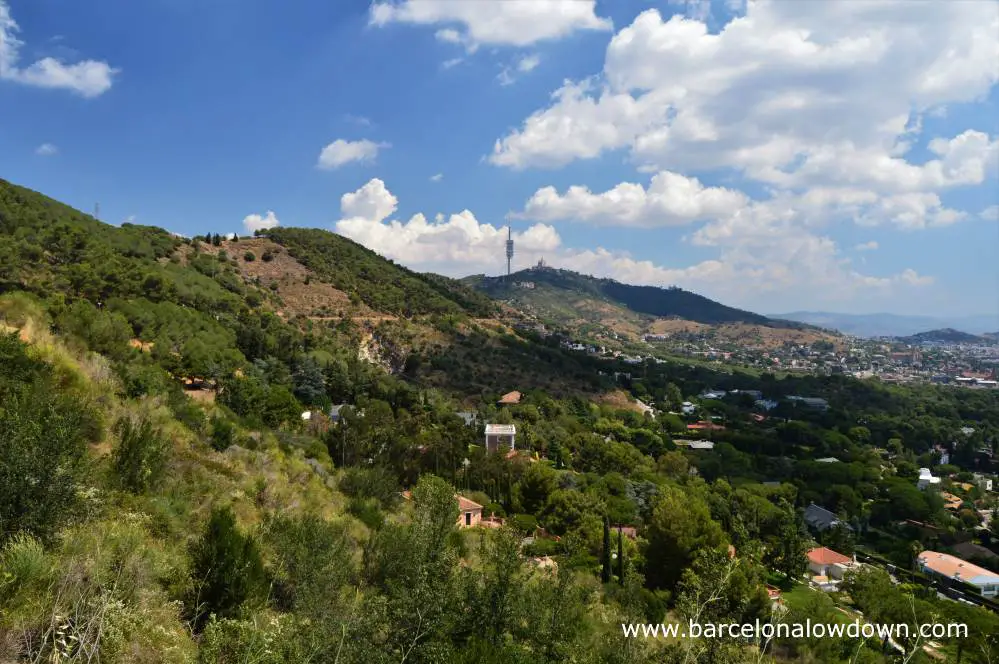 View of the La Carretera de les Aigües walking path in the mountains behind Barcelona. In the distance you can see the Collserola communications tower and the Tibidabo amusement theme park.