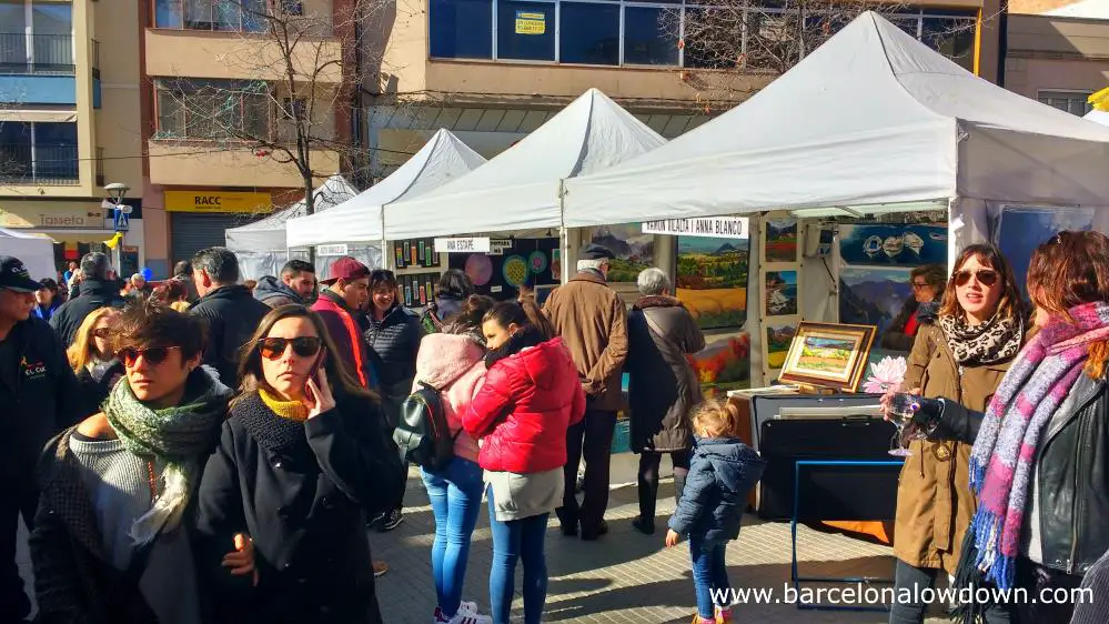 Market stalls selling colorful paintings at the Fira de la Candelera fair in Molins de Rei Barcelona Spain