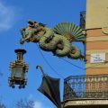 The painted steel Chinese dragon sign on the façade of the umbrella house Barcelona. The dragon is adorned by a fan, an umbrella and a bamboo lantern.