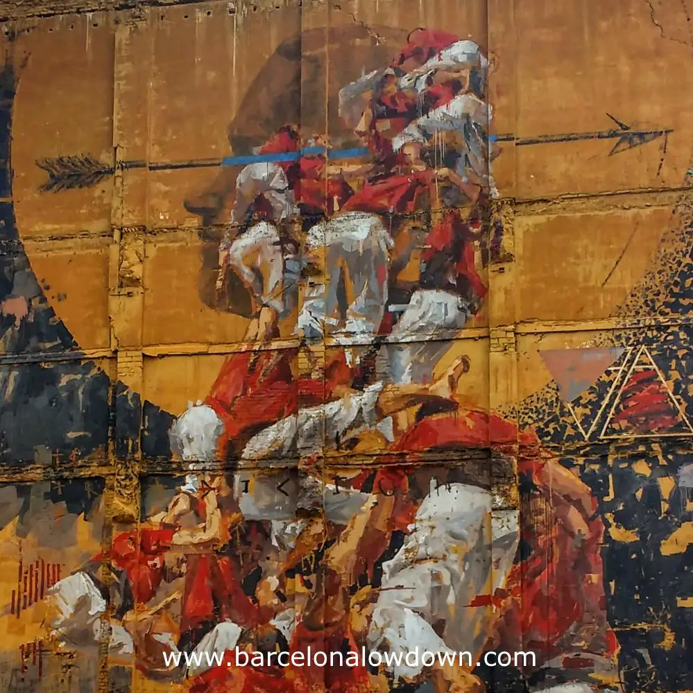 Closeup photo of the painting Fer Llenya. The painting shows a group of Castellers in the moment that the tower collapses. The background of the painting is the siluette of a person whose head is traversed by an arrow.