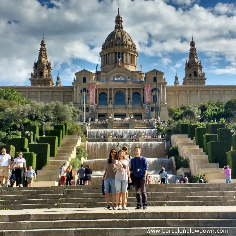 A group of people taking a selfie in front of the Palau Nacional in Barcelona. They probably uploaded it to Instagram and Facebook to show their friends back home what a good time they were having.