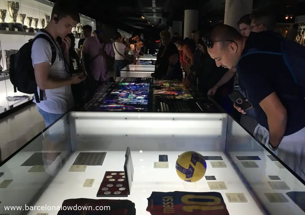 Barça fans looking at the memorabilia (Including one of Messi's shirts) on display in the FC Barcelona museum during the Camp Nou tour.