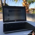 Photo of a laptop on a table in a sunny Marina near Barcelona - the barcelona lowdown blog is on the screen