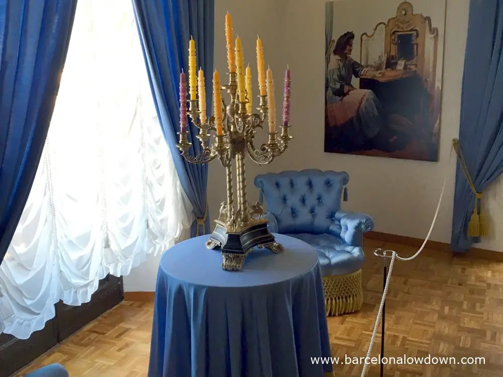 Ornate surrealist candlesticks ontop of a table covered bt a blue tebleclosth in Gala Dali castle in Pubol Spain