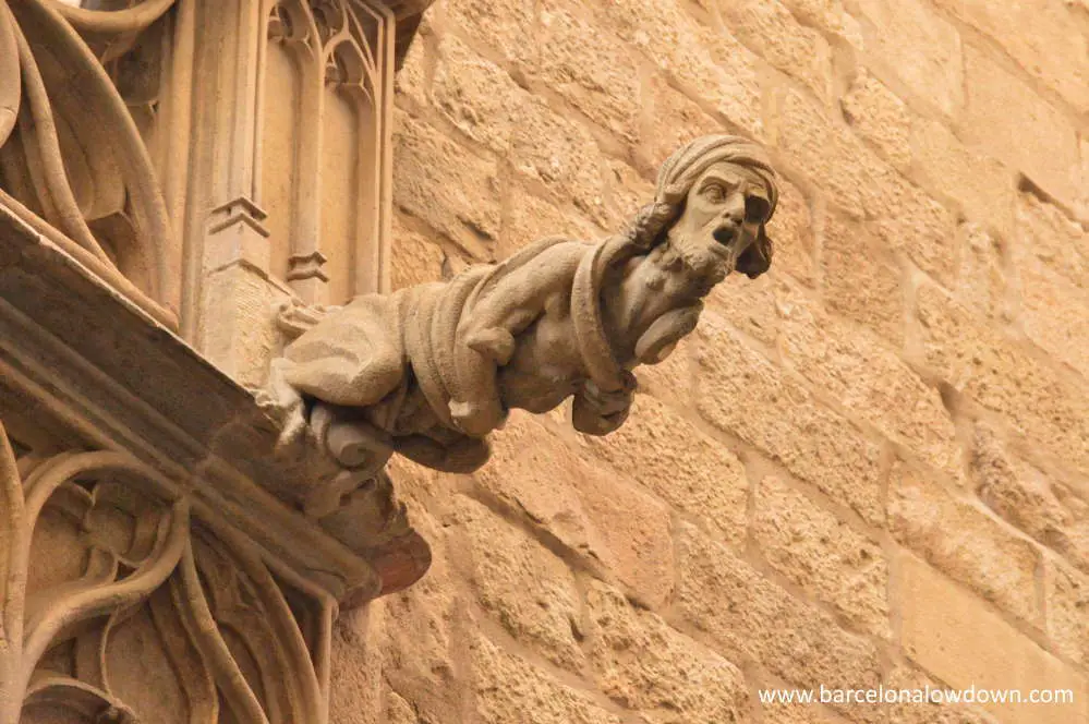 Stone gargoyle on the side of an old building in the Gothic Quarter of Barceona