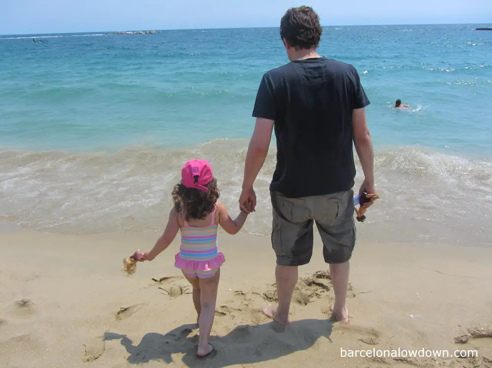 A child and hers toys enjoying the beach in Barcelona