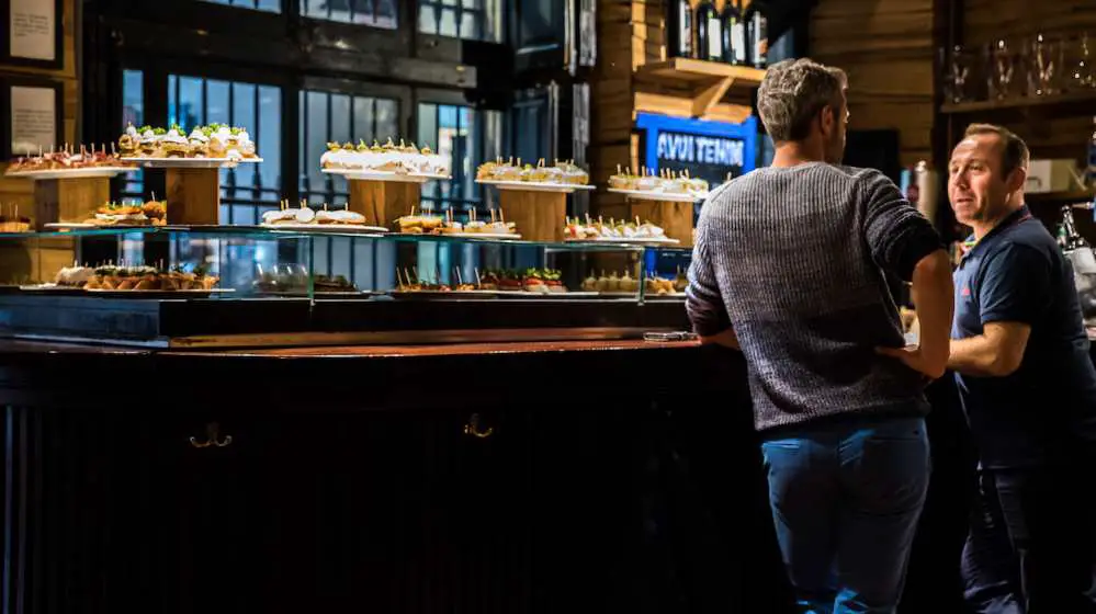 Two guys chatting in a pintxo bar in Barcelona - Photo by Ben Holbrook