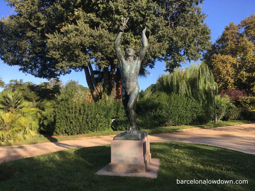 Bronze statue of a man with a dagger in a park in Barcelona