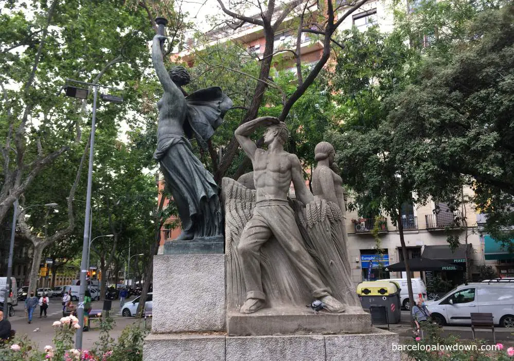 A monument in Barcelona depicting a semi nude woman holding a torch and a soviet style carving of a farmer