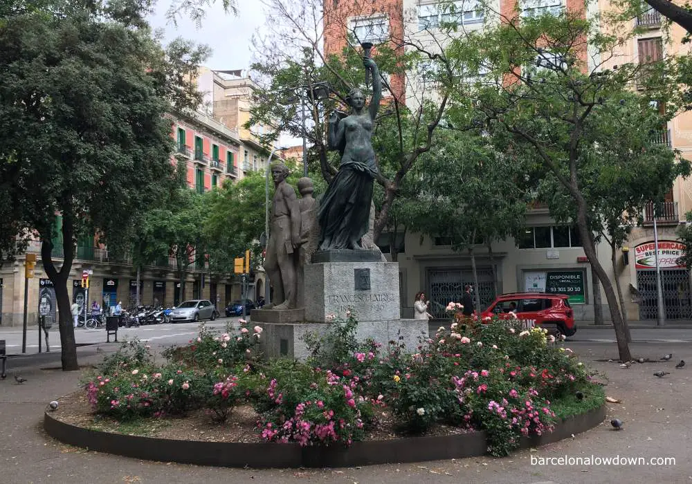 A statue in Barcelona depicting lady liberty flanked by soviet style depictions of workers