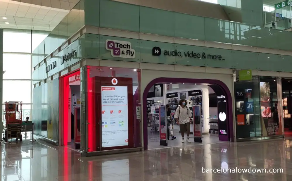 an electronics shop at Barcelona airport with a large poster advertising prepaid Spanish sim cards for mobile phones
