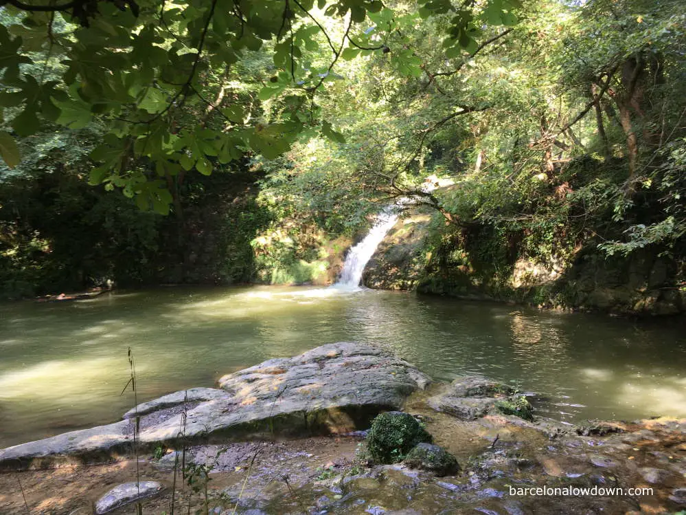 A small waterfall cascading into a swimming hole in Catalonia