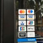 Sticker in a shop doorway in Barcelona showing which payment methods are accepted including contactless payments, Apple Pay and Google Pay