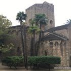 A small medieval romanesque church surrounded by palm trees in Barcelona