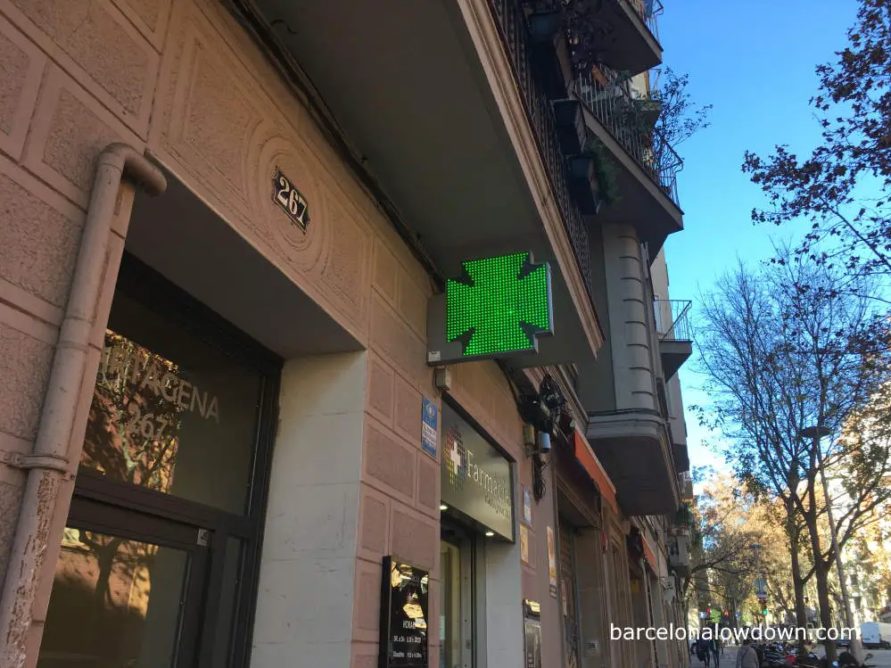 An illuminated green sign outside a pharmacy in Barcelona