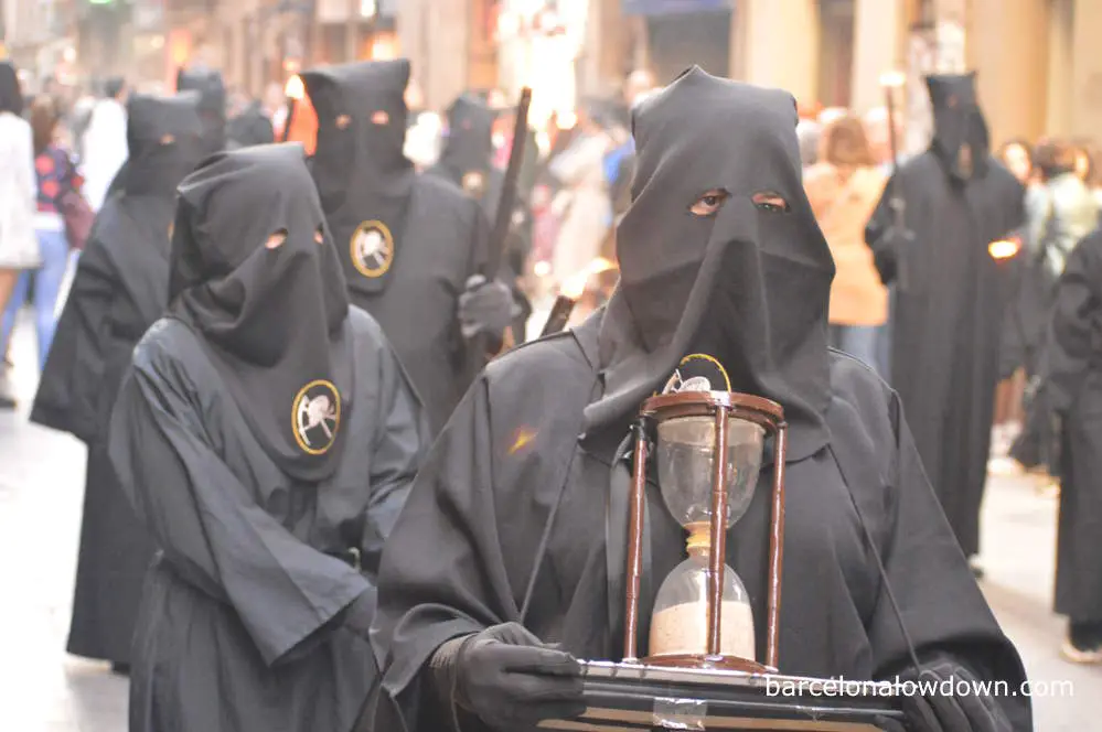 A hooded man carrying an hourglass in the Easter week celebrations in Barcelona