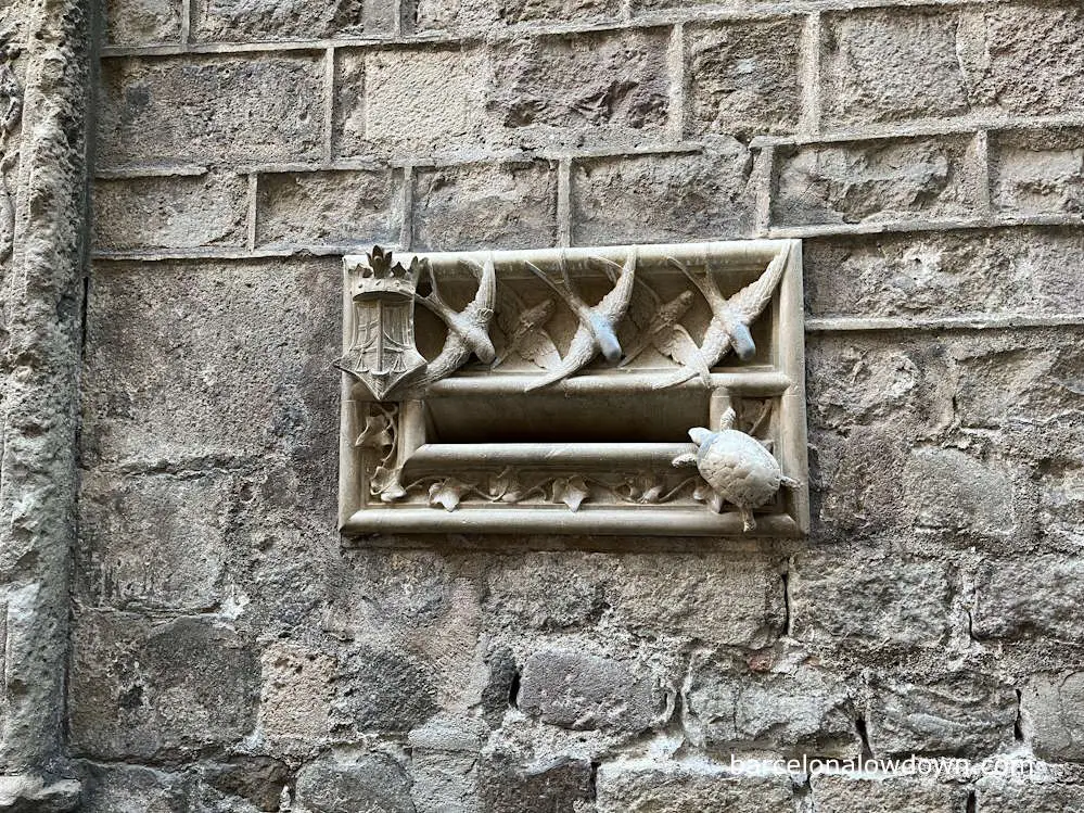 A modernist styled letterbox in Barcelona decorated with swallows, a turtle and ivy